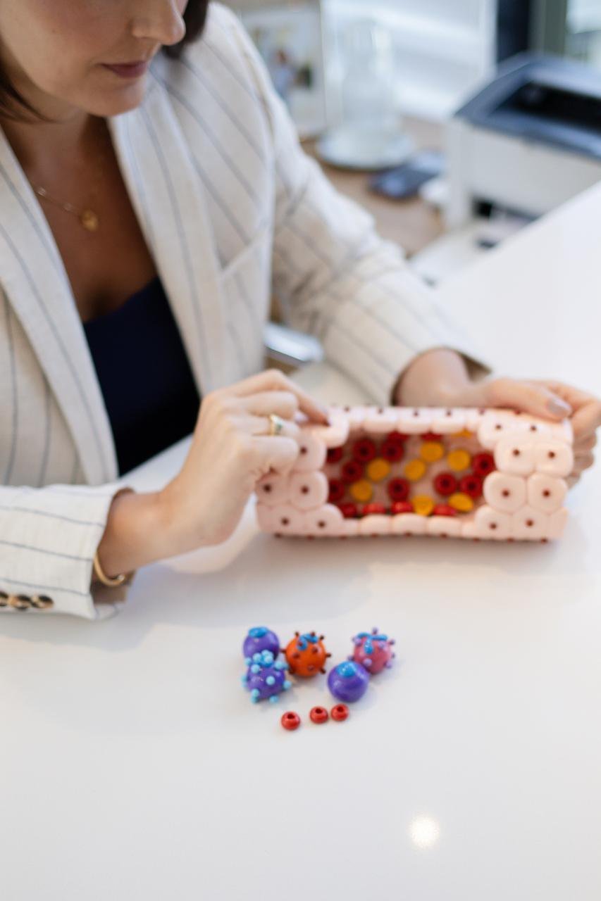 Dra. Andrezza Medina com um modelo didático de vaso sanguíneo mostrando as células do sangue